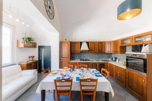 een keuken met een tafel met stoelen en een bank bij Maika House - Amalfi Coast - Seaview in Atrani