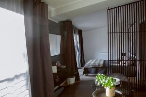 Un dormitorio con una cama y una mesa con una planta en Appartamento NEW YORK, en Torre dʼIsola