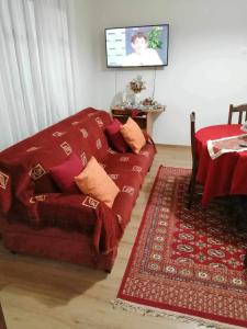 a living room with a red couch and a table at Villa Paradisos in Likóstomon