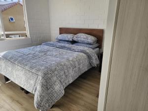 1 dormitorio con 1 cama con manta azul y almohadas en Casa Puertas del mar, en La Serena