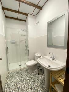 uma casa de banho com um chuveiro, um WC e um lavatório. em Apartamentos rurales, La Casa de Baltasar em Fondón