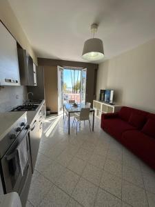 Una cocina y una sala de estar con un sofá rojo. en BELLAVITA, en Pozzallo