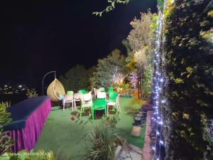 a garden with a table and chairs at night at Wonderful Homestay in Kasauli