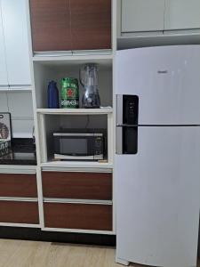 a kitchen with a refrigerator and a microwave at Apartamento Praia Grande SP in Praia Grande