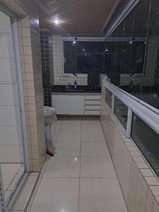 a bathroom with a sink and a tiled floor at Apartamento Praia Grande SP in Praia Grande