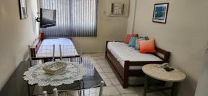 a small living room with a couch and a table at Angra inn - Angra dos Reis - apê120 in Angra dos Reis