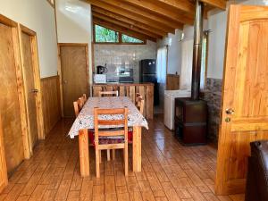 a kitchen with a table with chairs and a stove at Cabañas El Boldo in Licán Ray