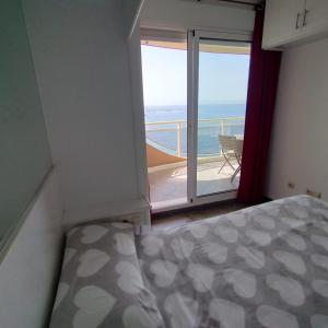 a bedroom with a bed and a balcony with the ocean at TERRAMAR in Villajoyosa
