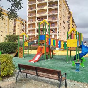 a playground with colorful play equipment in front of a building at TERRAMAR in Villajoyosa