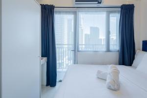 a bedroom with a bed and a large window at Lush Residences Makati in Manila