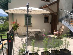 patio ze stołem, krzesłami i parasolem w obiekcie LA DENT PARRACHEE w mieście Termignon