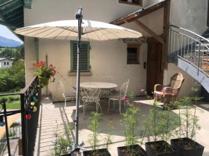 a patio with a table and chairs and an umbrella at LA DENT PARRACHEE in Termignon +3 photos