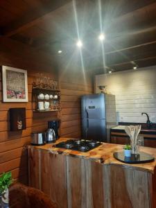 een keuken met een aanrecht met een fornuis en een koelkast bij Cabana na montanha, com hidro e vista espetacular. 