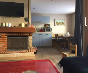 Cosy and spacious family nest with superb view في كورشوفيل: غرفة معيشة مع موقد ومطبخ