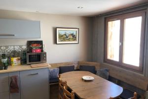 een keuken met een tafel en een tafel en een magnetron bij Cosy and spacious family nest with superb view in Courchevel
