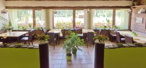 ein Restaurant mit Tischen, Stühlen und Topfpflanzen in der Unterkunft Frühstückspension Seeberghof in Seewiesen