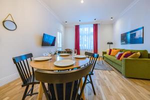a dining room with a table and a green couch at Apartamenty House Managers - Bursztynowa Zatoka in Sopot