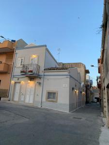 Un edificio bianco seduto sul lato di una strada di CAPINERA a Pozzallo