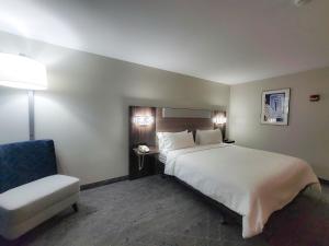 Habitación de hotel con cama y silla en Holiday Inn Express Enid-Highway 412, an IHG Hotel, en Enid