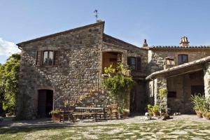 une maison en pierre avec une table et des chaises dans la cour dans l'établissement Agriturismo Fattoria Walden, à Ficulle