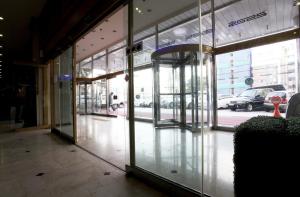 an empty hallway of a building with glass doors at Jeju Royal Hotel in Jeju