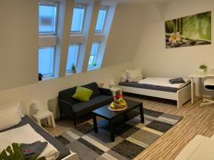 ein Wohnzimmer mit einem Sofa, einem Bett und einem Tisch in der Unterkunft CityApartment Platinum-Zentrum mit Parkplatz in Bielefeld