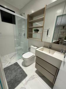 a bathroom with a toilet and a sink and a shower at Infinity Tower Flat - 1403 in Itapema
