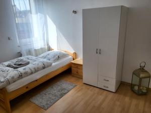 - une chambre avec un lit et une armoire blanche dans l'établissement Ferienwohnung Gästehaus Bauer, à Heiligenhaus