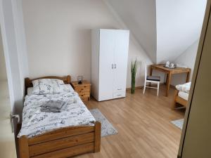 een slaapkamer met een bed, een kast en een bureau bij Ferienwohnung Gästehaus Bauer in Heiligenhaus