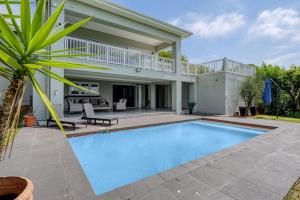 a swimming pool in front of a house at Gemmell Place by HostAgents in Durban