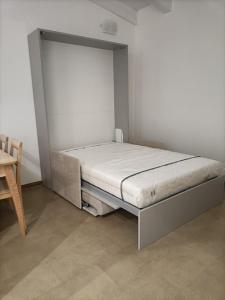 Cama en habitación con pared blanca en I Due Olmi en Módena