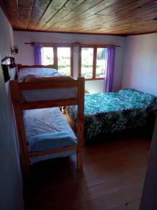 two bunk beds in a room with a window at KM SUN HOSTEL in San Carlos de Bariloche