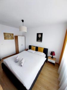 um quarto com uma cama branca com duas almofadas em Panoramic City View Apartment em Târgu-Mureş