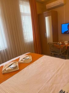een hotelkamer met een bed met twee schoenen erop bij AURA HOTEL in Istanbul