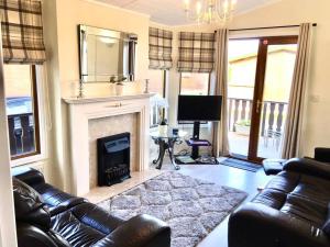 a living room with a couch and a fireplace at Luxury 3 bedroom lodge with free in lodge wifi in Carnforth