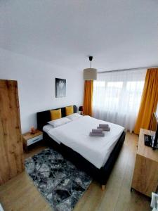 um quarto com uma cama grande e toalhas em Panoramic City View Apartment em Târgu-Mureş