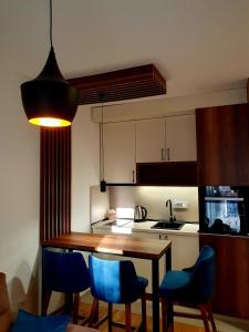 a kitchen with a wooden table and blue chairs at Apartman Felicita 2 in Zlatibor +5 photos