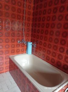 een badkamer met een bad en rode betegelde muren bij Casa Mareque in Pontevedra