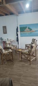a room with chairs and a painting on the wall at Cabana praia dos passarinhos in Viamão