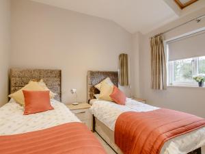 2 bedden in een kleine slaapkamer met een raam bij Sunnyside Shreyas in Wilpshire
