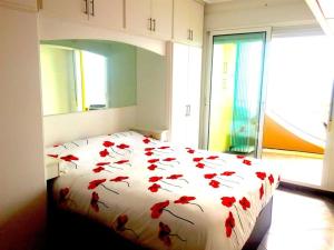 a bedroom with a bed with red flowers on it at TERRAMAR in Villajoyosa