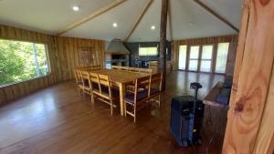 a room with a table and chairs in a house at Cabañas tunquelen in Osorno