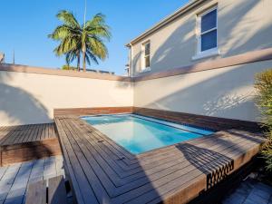 a swimming pool with a wooden deck next to a house at Dock Point 1 in Durban