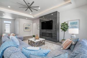 ein Wohnzimmer mit 2 blauen Sofas und einem TV in der Unterkunft Pecan Valley Modern Poolhouse in Hurricane near Sand Hollow in Hurricane