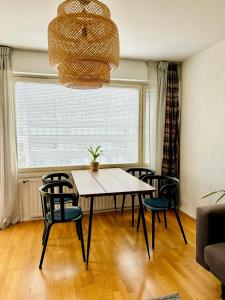 a dining room with a table and chairs and a chandelier at Turku Downtown Cozy Flat with balcony 45m2 in Turku