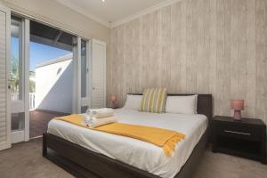 a bedroom with a bed and a large window at Beach Haven Townhouse in Durban
