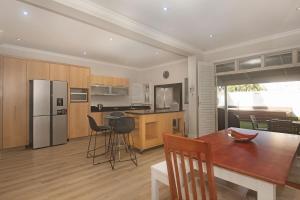 a kitchen with a wooden table and a kitchen with a refrigerator at Beach Haven Townhouse in Durban