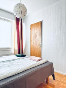 a room with a bed with a door and a window at Turku Downtown Cozy Flat with balcony 45m2 in Turku