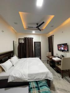 a bedroom with a bed and a desk and a television at Homestay Comforts 500m from Amritsar Airport in Amritsar