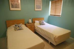 two beds sitting next to each other in a bedroom at Seaside Serenity - A lovely apartment with views in Mellieħa